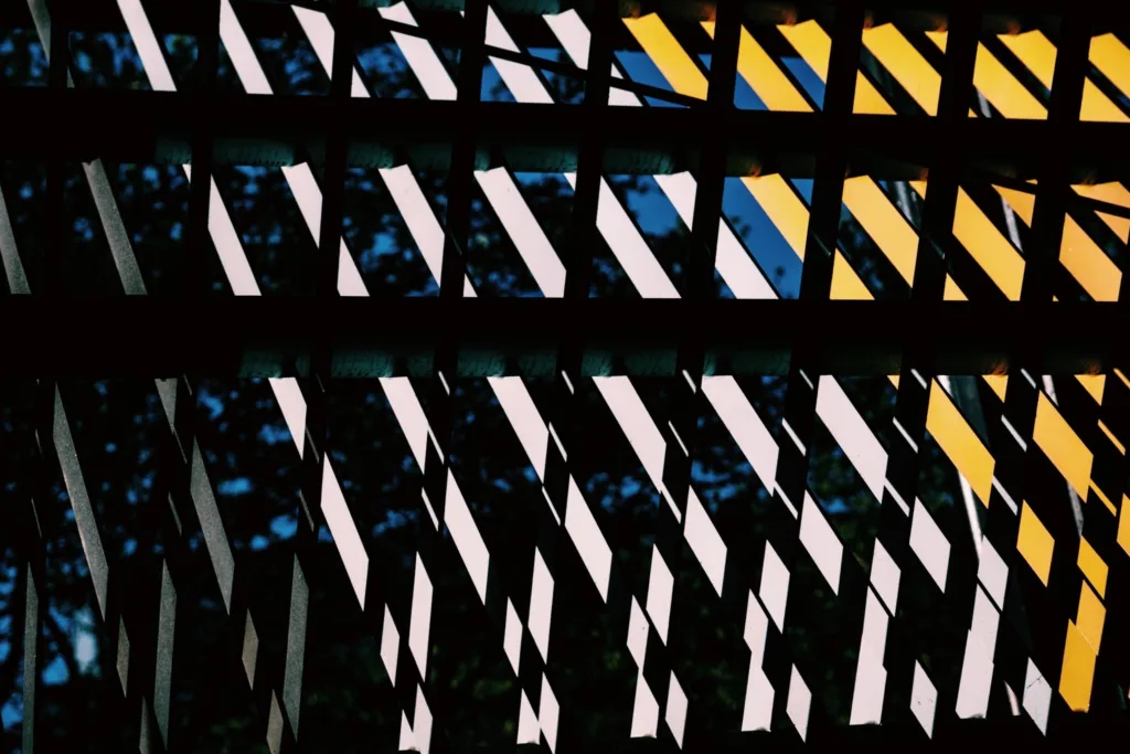 Graphic facade pattern of light and dark panels with blue and yellow accents