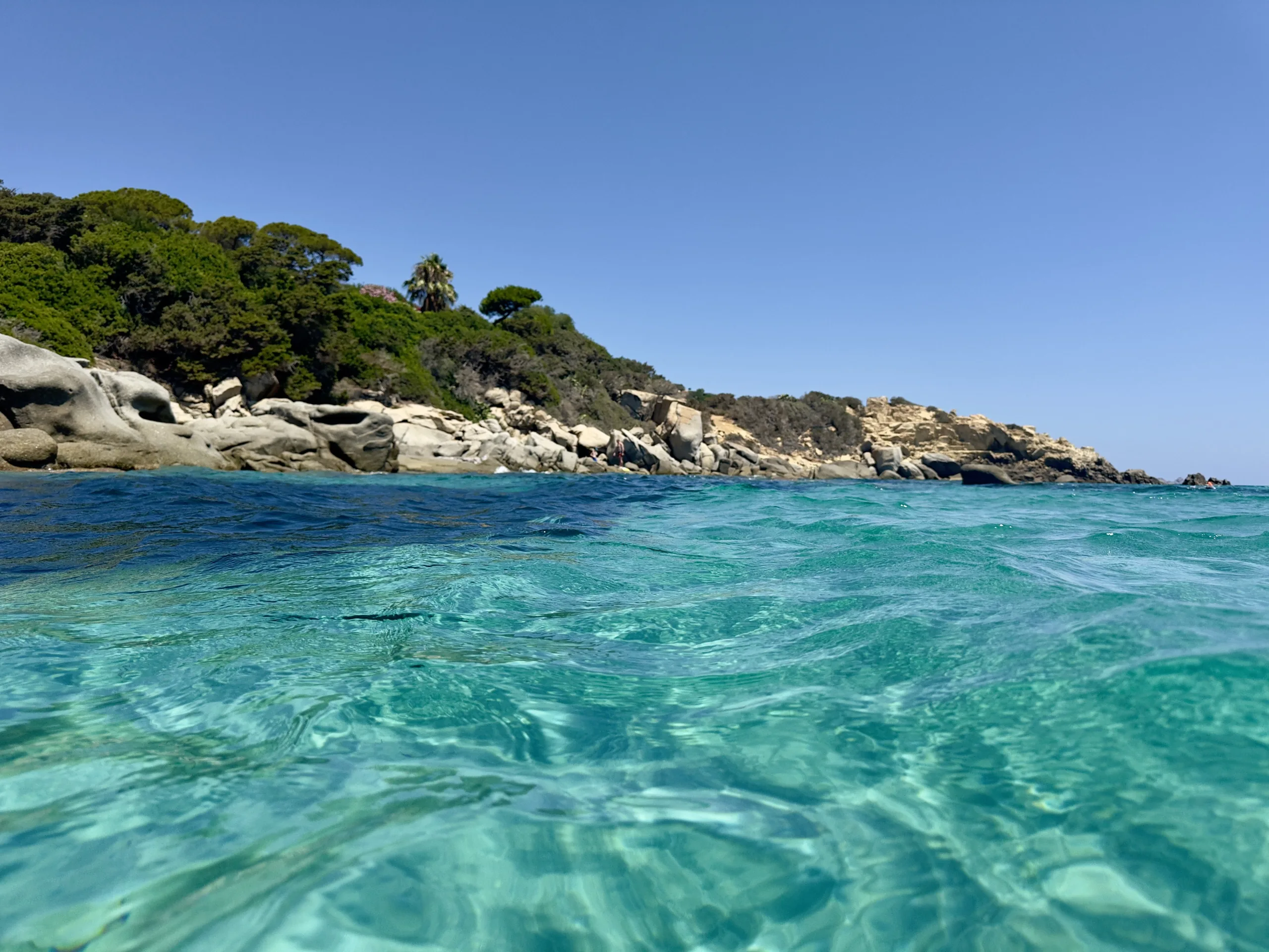 Bay in Sardinia with turquoise water and a rocky shore